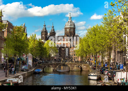 St. Nikolaus Basilika anzeigen. Frühling Tag in Amsterdam mit Brücke, Boote und Fahrräder Stockfoto