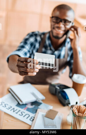 Selektiver Fokus der afrikanischen amerikanischen Mann mit Kreditkarte im Coffee Shop Stockfoto