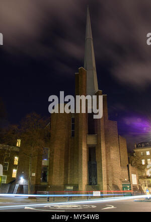 London, England, UK - 12. Februar 2018: Die Lichter der Fahrzeuge passieren des modernen St Saviour Kirche an der Warwick Avenue in London. Stockfoto