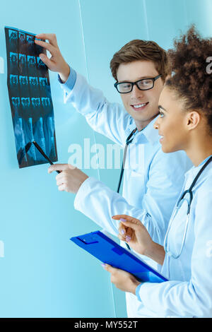 Zwei junge lächelnde Ärzte Prüfung eines x-ray Foto Stockfoto