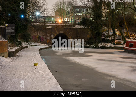 London, England, UK - 1. März 2018: Schnee liegt auf einem leinpfad neben dem gefrorenen Gewässern des Regent's Canal in Islington Tunnel in London. Stockfoto