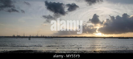 Den Sonnenuntergang Silhouetten der industriellen Türme von Fawley Ölraffinerie am Ufer des Southampton Wasser, von netley gesehen. Stockfoto