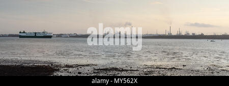 Den Sonnenuntergang Silhouetten der industriellen Türme von Fawley Ölraffinerie am Ufer des Southampton Wasser, von netley gesehen. Stockfoto