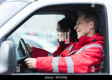 Lächelnd männlichen und weiblichen Sanitäter in Krankenwagen sitzen Stockfoto