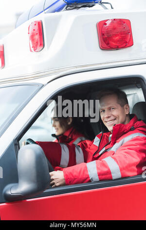 Gerne männliche und weibliche Sanitäter in Krankenwagen sitzen Stockfoto