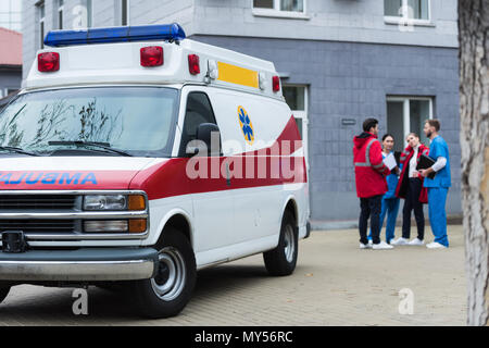 Vier Krankenwagen Ärzte sprechen und stehen in der Nähe des Auto Stockfoto