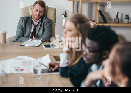 Gruppe von müde Manager und Chef sitzt im Konferenzsaal im Büro Stockfoto