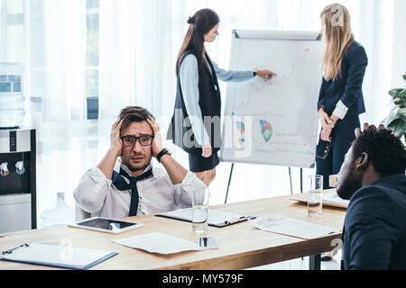 Gestresste Geschäftsleute in Konferenzsaal im Büro Stockfoto