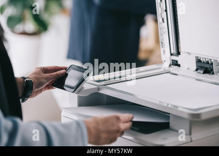 7/8 Schoß der Frau in formale Abnutzung mit modernen Kopierer Stockfoto