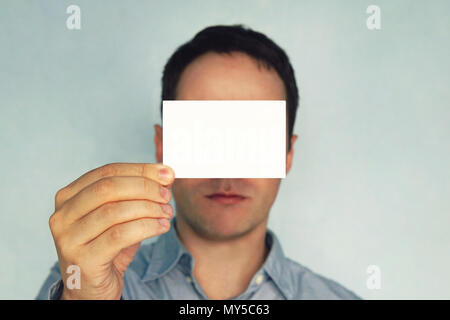Junger Mann mit Besuch Karte. Geschäftsmann schließt seine Augen Business Card. Leer für Text. Weiße Visitenkarte in der Hand. Horizontale Mockup Stockfoto