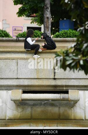 Madrid, Spanien. 5. Juni 2018. Zwei Mädchen sitzen, die von einem Garten im El Escorial, Spanien, am 5. Juni 2018. Quelle: Guo Qiuda/Xinhua/Alamy leben Nachrichten Stockfoto