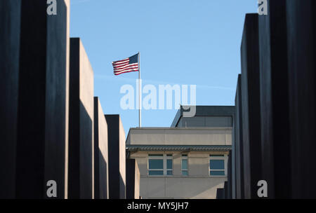 06 Juni 2018, Deutschland, Berlin: Die Flagge der Vereinigten Staaten von Amerika weht auf dem Dach der US-Botschaft, während im Vordergrund die Säulen des Denkmals für die ermordeten Juden Europas zeigt. Der neue US-Botschafter und Trump vertrauter R. Grenell Kritik nur wenige Wochen nach seiner Amtseinführung. Foto: Paul Zinken/dpa Stockfoto