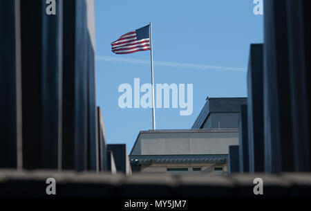 06 Juni 2018, Deutschland, Berlin: Die Flagge der Vereinigten Staaten von Amerika weht auf dem Dach der US-Botschaft, während im Vordergrund die Säulen des Denkmals für die ermordeten Juden Europas zeigt. Der neue US-Botschafter und Trump vertrauter R. Grenell Kritik nur wenige Wochen nach seiner Amtseinführung. Foto: Paul Zinken/dpa Stockfoto