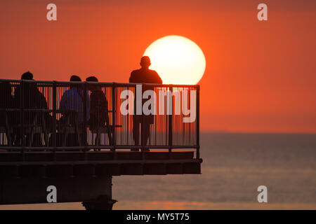 Aberystwyth Wales UK, Mittwoch, 06. Juni 2018 Deutschland Wetter: Die heißen, sonnigen Sommer Sonnenschein weiter, die ihren Höhepunkt in einem herrlichen Sonnenuntergang über dem Meer Pier in Aberystwyth auf der Cardigan Bay Küste von West Wales Foto © Keith Morris/Alamy leben Nachrichten Stockfoto