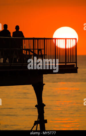 Aberystwyth Wales UK, Mittwoch, 06. Juni 2018 Deutschland Wetter: Die heißen, sonnigen Sommer Sonnenschein weiter, die ihren Höhepunkt in einem herrlichen Sonnenuntergang über dem Meer Pier in Aberystwyth auf der Cardigan Bay Küste von West Wales Foto © Keith Morris/Alamy leben Nachrichten Stockfoto