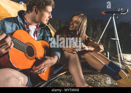 Glücklicher Mann Gitarre spielen für Freundin in Wandern Reise Stockfoto