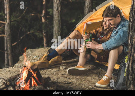 Entspannende Paar auf Wanderung Bier trinken zusammen, während im Zelt sitzen Stockfoto