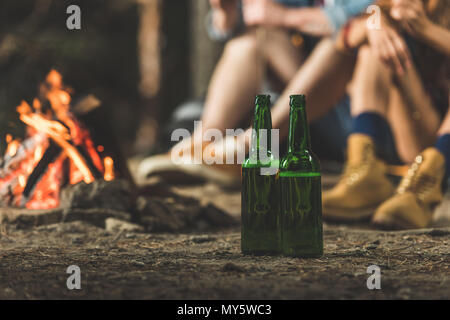 Flaschen Bier in Wandern Camp neben Lagerfeuer Stockfoto