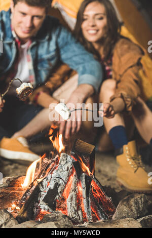 Junges Paar rösten Marshmallow auf Sticks in camping Reise Stockfoto