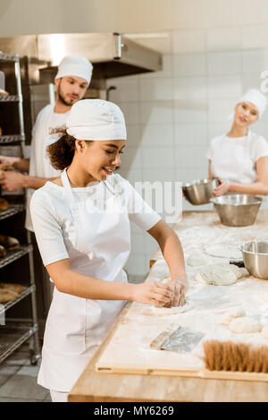 Multiethnische Team der Bäcker zusammen zu backen Herstellung arbeiten Stockfoto