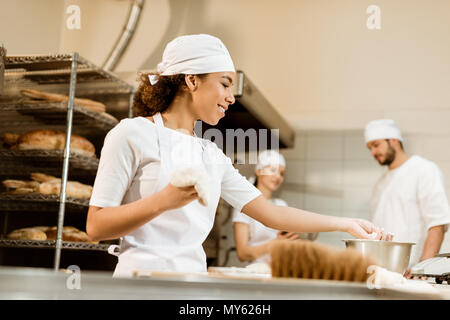 Multiethnische Team der Bäcker zusammen zu backen Herstellung arbeiten Stockfoto