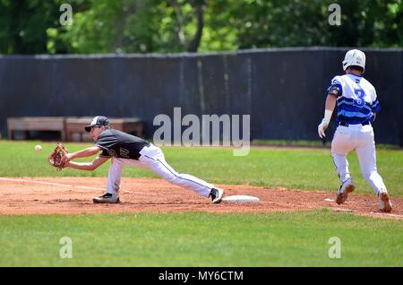 Erste Basisspieler Stretching zu sichern Eine von einem infielder eine gegnerische hitter in den Ruhestand zu werfen. USA. Stockfoto