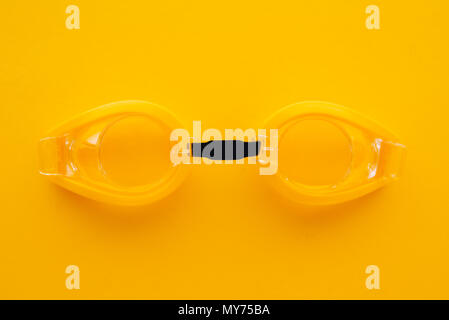 Schwimmbrille auf gelbem Hintergrund, Ansicht von oben flach minimale Zusammensetzung Stockfoto