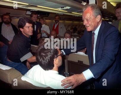 Der SPD-Ehrenvorsitzende Willy Brandt, 76, schüttelt Hände mit Geiseln im Irak freigelassen, an Bord einer Lufthansa-Maschine nach Frankfurt/Main am 9. November 1990. Brandt gesichert die Freilassung von 175 Ausländer im Irak gehalten, darunter 120 Deutsche, nach fünf Tagen der Verhandlungen. Die Geiseln wurden von den Irak nach dem Ausbruch der Golfkrise (2. August 1990) verhindert. | Verwendung weltweit Stockfoto