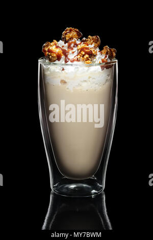 Doppelwandige Glas mit Kaffee cocktail dekoriert mit Schlagsahne und Popcorn isoliert auf Schwarz Stockfoto