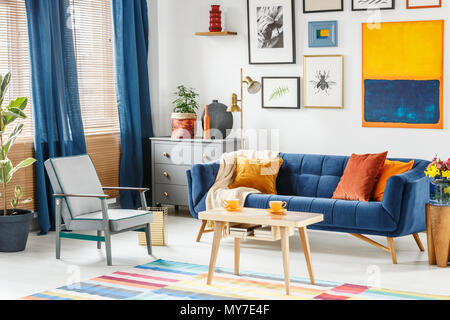 Blaues Sofa mit weißen Kissen in modernen weißen offenen Wohnzimmer und