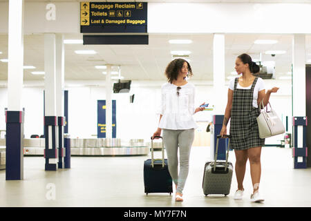 Freunde mit Rädern Koffer im Flughafen Stockfoto