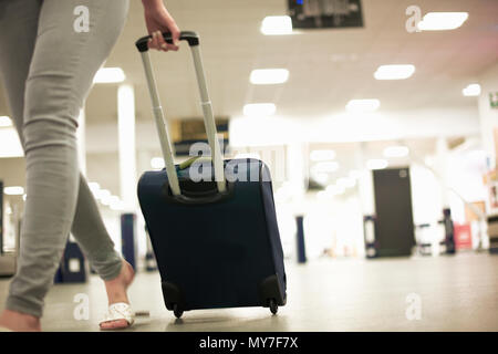 Frau mit Rädern Koffer im Flughafen Stockfoto