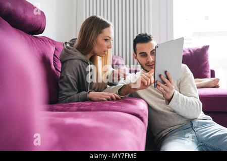 Paar erholsame auf Sofa mit digital-Tablette Stockfoto