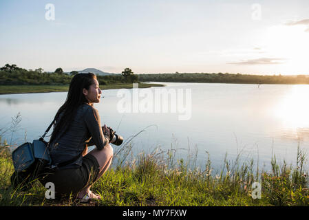 Junge weibliche Touristen mit Blick über den Fluss in den Krüger National Park, Südafrika Stockfoto