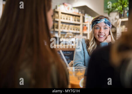 Drei weibliche Freunde, im Café sitzen, aufholen, trinken Smoothies Stockfoto