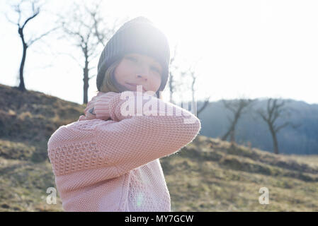 Sunlit Portrait von Mitte der erwachsenen Frau tragen Strickmütze im Feld Stockfoto