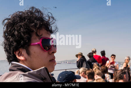 Männliche Touristen tragen in Herzform rosa Sonnenbrille, Fahrten auf Ellis Island Ferry, New York City, USA Stockfoto