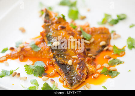 Makrelen mit Harissa Paste auf ein Rezept von der BBC Website gutes Essen gekocht. Die Makrelen werden mit Mehl bestäubt und geräuchertem Pap Stockfoto