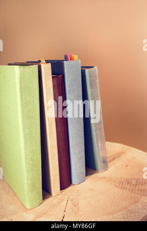 Retro getonten Bild der vertikalen Stapel alter Bücher auf hölzernen Säge schneiden. Stockfoto