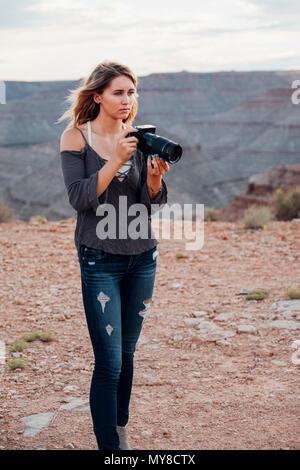 Junge Frau im Freien, SLR-Kamera, Fotografieren Umgebung, Mexican Hat, Utah, USA Stockfoto