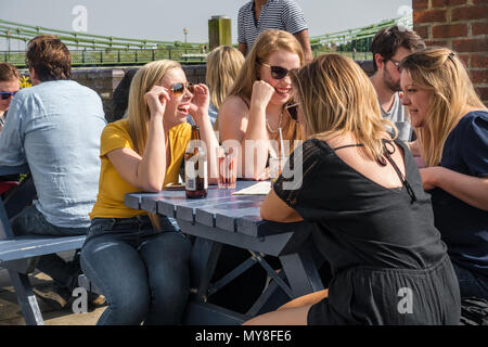 Eine Gruppe von Freunden einen Drink und ein Lachen zusammen in einem Biergarten auf der unteren Mall in Hammersmith, London, Großbritannien. Stockfoto