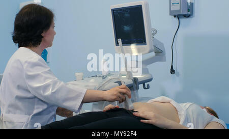 Ärztin, Gel auf Patienten Magen für Ultraschall Stockfoto