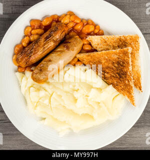 Würstchen mit gebackenen Bohnen und Kartoffelpüree und geröstetem Brot Stockfoto