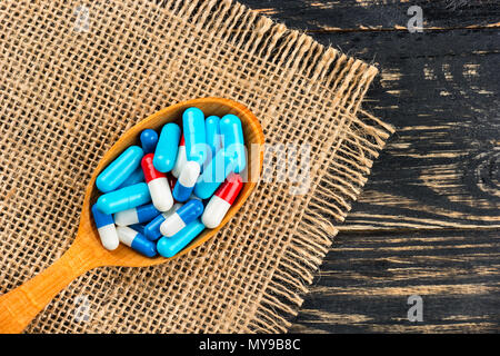 Mehrfarbige Kapseln in einem Kochlöffel auf Plünderungen - Ansicht von oben Stockfoto