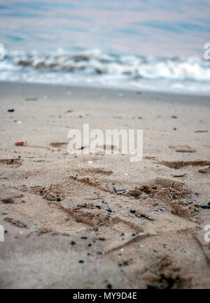 EDINBURGH, SCHOTTLAND - 21. JANUAR 2011: Eine Nahaufnahme des Sandes und eine Welle, die auf den Strand von Portobello kommt. Stockfoto