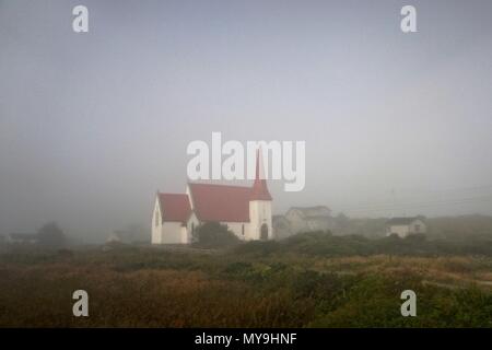 Nova Scotia, Kanada: Eine weiße Kirche mit einem roten Dach und Turm in einem frühen - Morgennebel gehüllt. Stockfoto