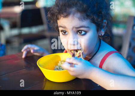 Ein Indisches Mädchen Nudeln essen im Restaurant Stockfoto