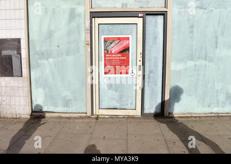 Die Schatten von Menschen zu Fuß an der geschlossenen Niederlassung der Bank Santander auf Kentish Town Road. Banken schließen mehr Niederlassungen auf der High Street als Stockfoto