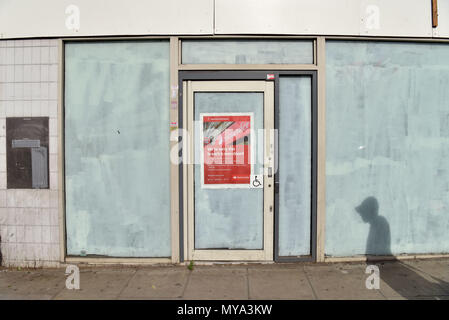 Die Schatten von Menschen zu Fuß an der geschlossenen Niederlassung der Bank Santander auf Kentish Town Road. Banken schließen mehr Niederlassungen auf der High Street als Stockfoto