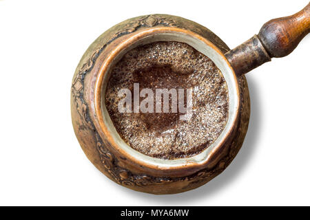 Eine alte Kaffeemaschine im Nahen Osten gemacht. Kaffee Schaum auf der Oberfläche. Türkischer Kaffee. Isoliert Foto auf einem weißen Hintergrund. Stockfoto